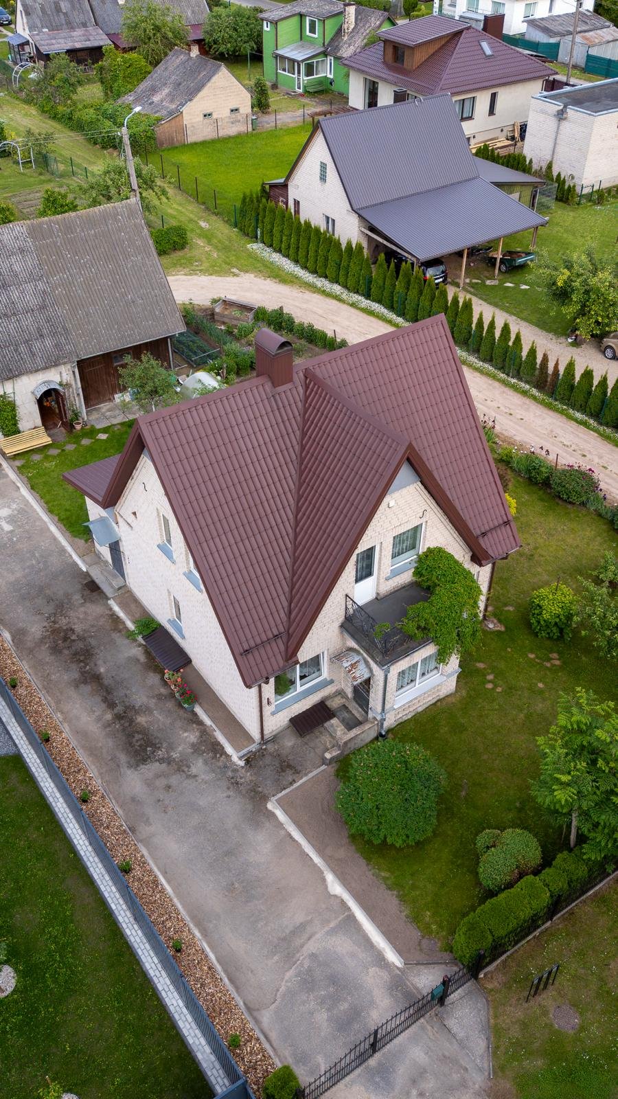 Iš oro matomas renovuotas rudos spalvos sudėtingos formos skardinis stogas