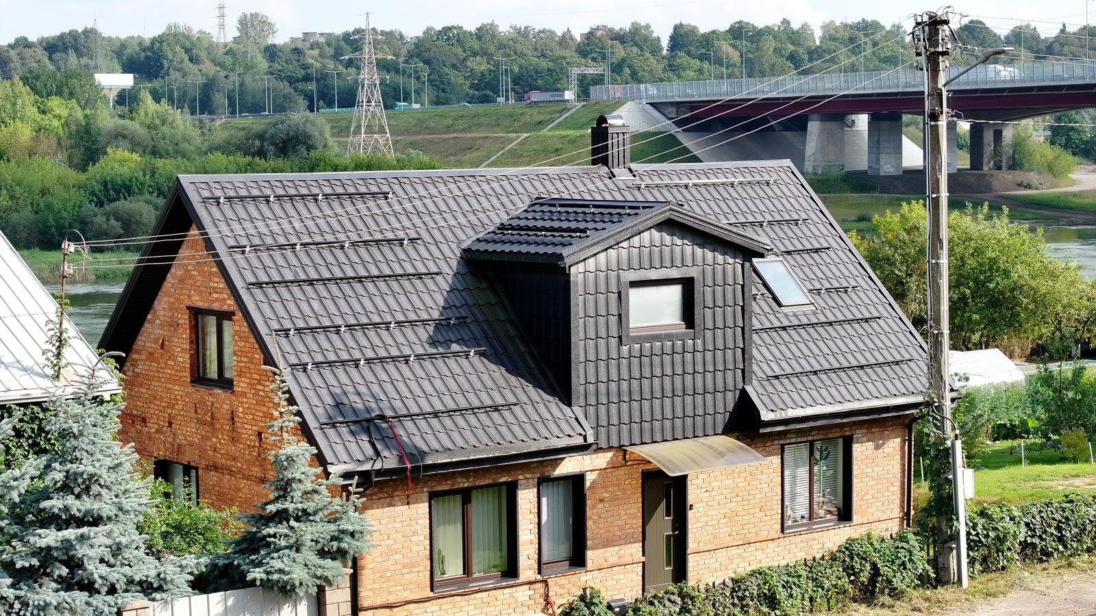 Renovuotas tamsus stogas su mansarda, stoglangiu ir sniego užtvaromis